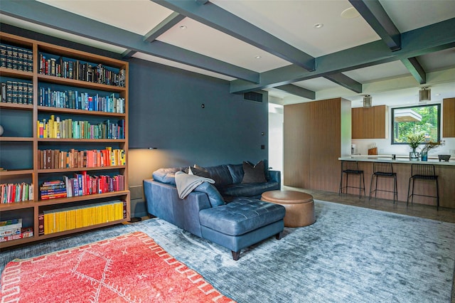 living area featuring beamed ceiling and visible vents