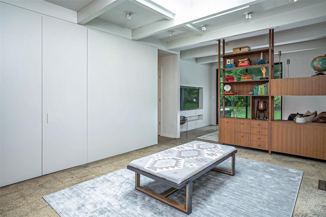 living room with beam ceiling and speckled floor