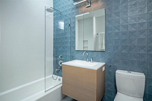 full bathroom featuring shower / washtub combination, toilet, tile walls, and vanity