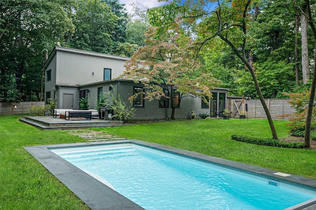 view of swimming pool with a fenced in pool, a fenced backyard, a lawn, and a deck