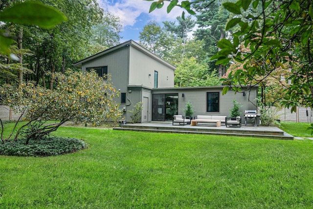 rear view of house with a yard, an outdoor living space, and a patio