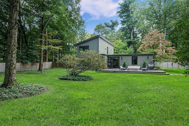 view of yard featuring outdoor lounge area, fence, and a wooden deck