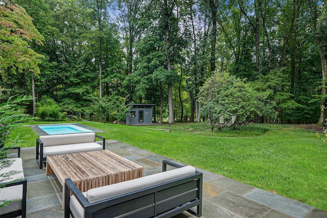 view of yard with an outbuilding, an outdoor hangout area, an outdoor pool, a shed, and a patio area