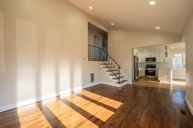 unfurnished living room featuring light wood-type flooring and high vaulted ceiling