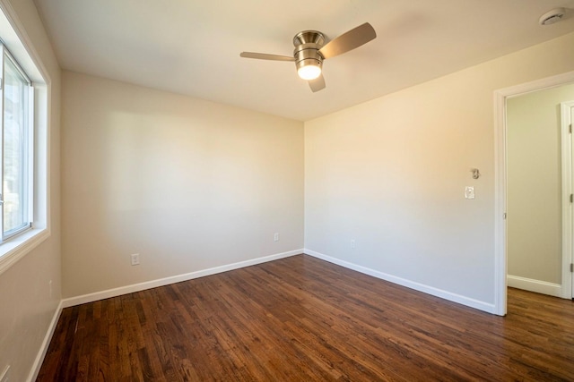 empty room with dark hardwood / wood-style floors and ceiling fan