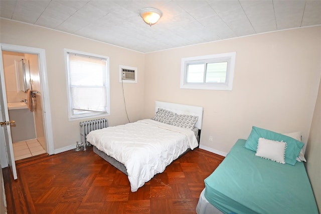 bedroom with an AC wall unit, radiator heating unit, and dark parquet floors