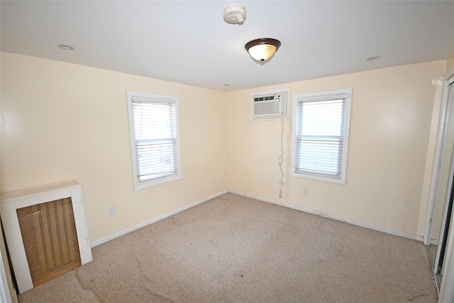 carpeted spare room with a wall mounted AC and plenty of natural light