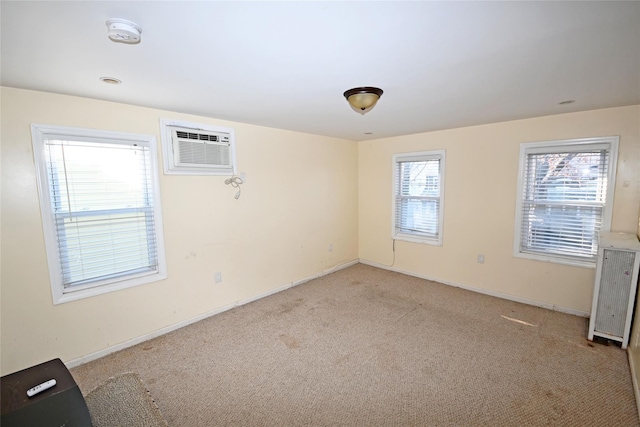 carpeted spare room featuring a wall unit AC