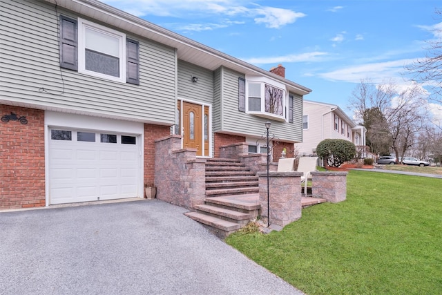 raised ranch with a front lawn and a garage