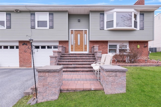 bi-level home featuring cooling unit and a garage