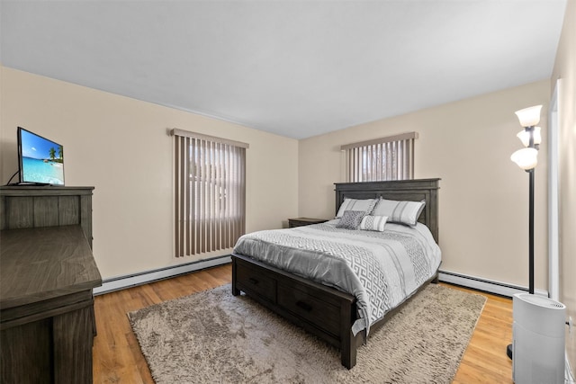 bedroom featuring light wood-type flooring and baseboard heating