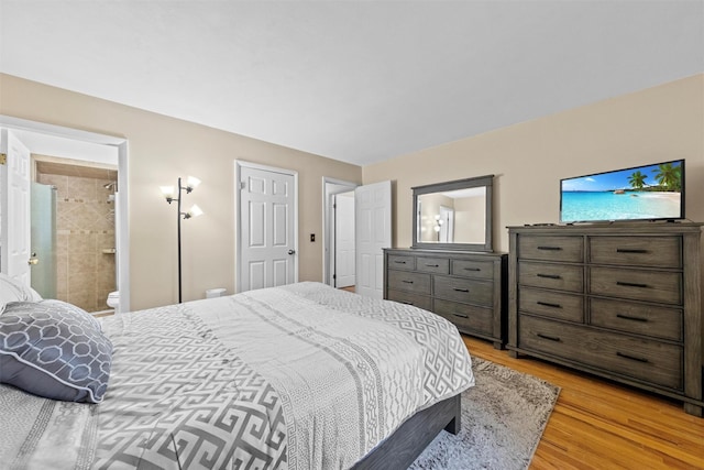 bedroom featuring ensuite bathroom and light wood-type flooring