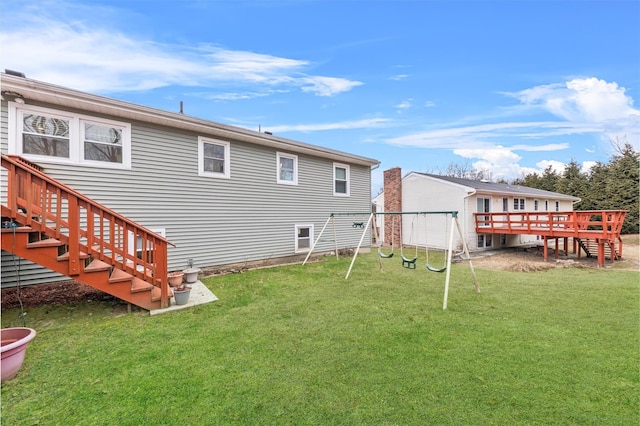 back of house with a lawn, a playground, and a wooden deck