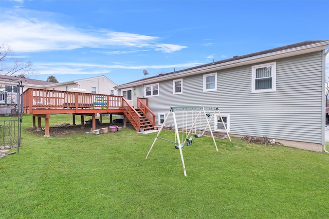 rear view of property featuring a lawn and a deck