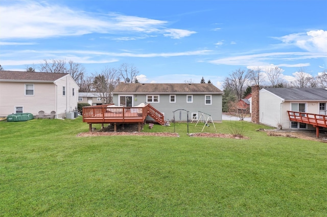 rear view of property featuring a yard and a wooden deck