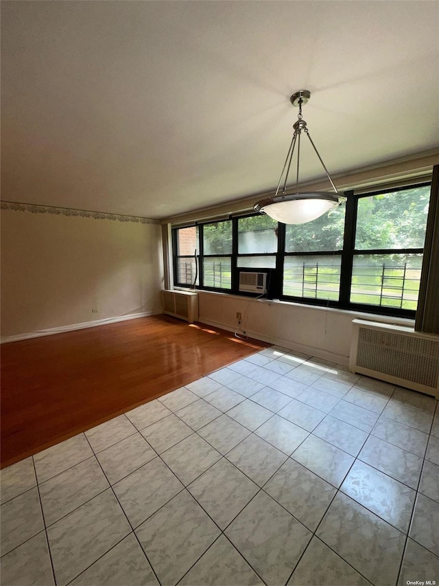 tiled spare room featuring radiator heating unit