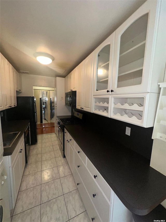 kitchen with white cabinetry, sink, and black appliances