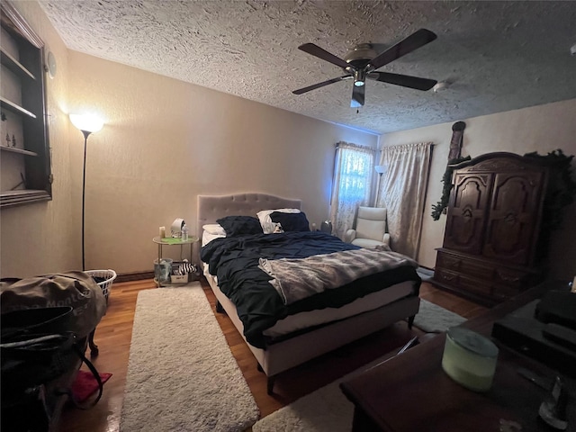 bedroom with wood-type flooring, a textured ceiling, and ceiling fan