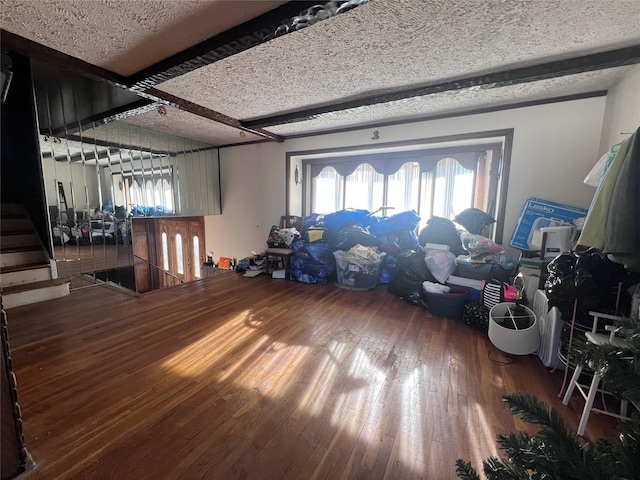 miscellaneous room featuring hardwood / wood-style flooring, beam ceiling, and a textured ceiling