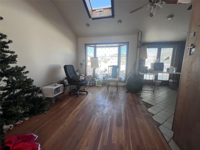 office space with ceiling fan, dark wood-type flooring, and vaulted ceiling with skylight