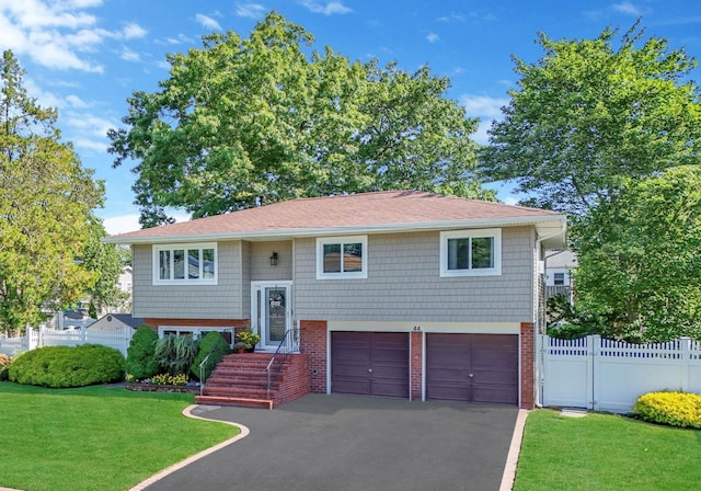 bi-level home featuring a front yard and a garage