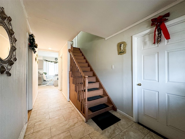 stairs with tile patterned flooring and ornamental molding