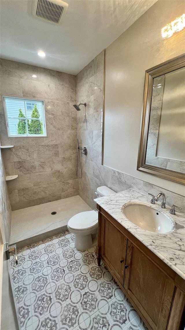 57 William St, Bethpage, NY 11714 - bathroom featuring tiled shower, vanity, and tile walls
