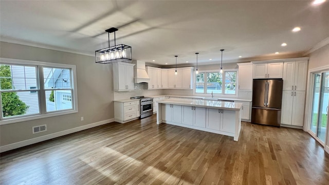 57 William St, Bethpage, NY 11714 - kitchen with stainless steel appliances, custom exhaust hood, light countertops, crown molding, and white cabinets