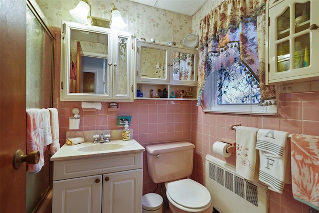 bathroom with vanity, toilet, and radiator