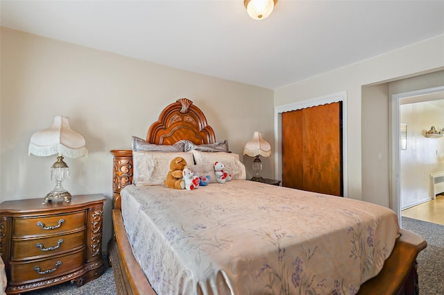 bedroom featuring a closet, carpet, and radiator heating unit