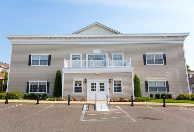 view of front of home with french doors and a balcony