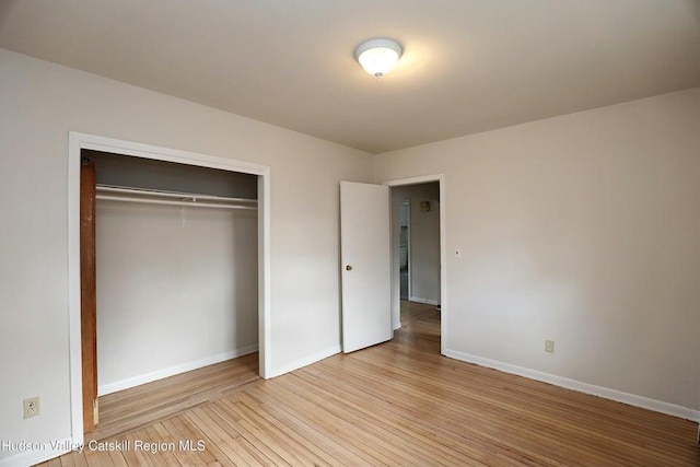 unfurnished bedroom featuring light hardwood / wood-style flooring and a closet