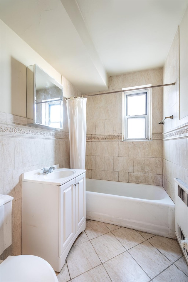 full bathroom featuring radiator, toilet, shower / bath combo with shower curtain, vanity, and tile walls