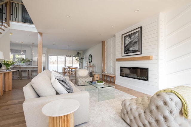 living room with light hardwood / wood-style floors, a fireplace, and a healthy amount of sunlight