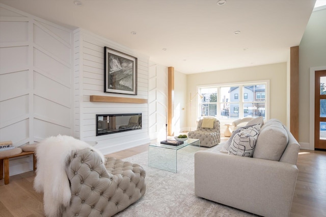 living room with light wood-type flooring and a fireplace