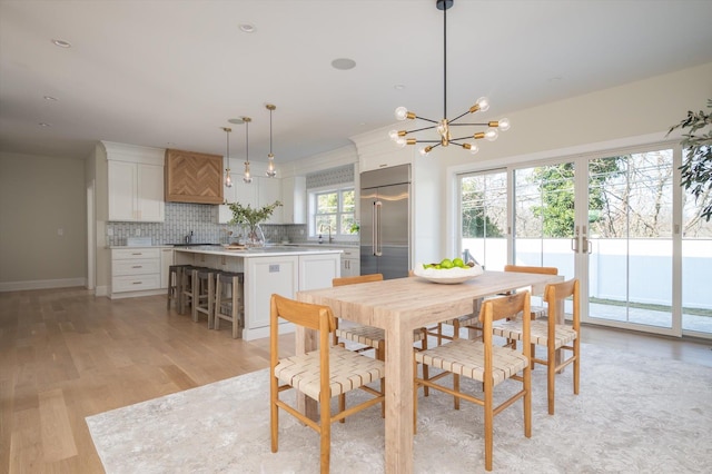 dining area with light wood-type flooring and sink