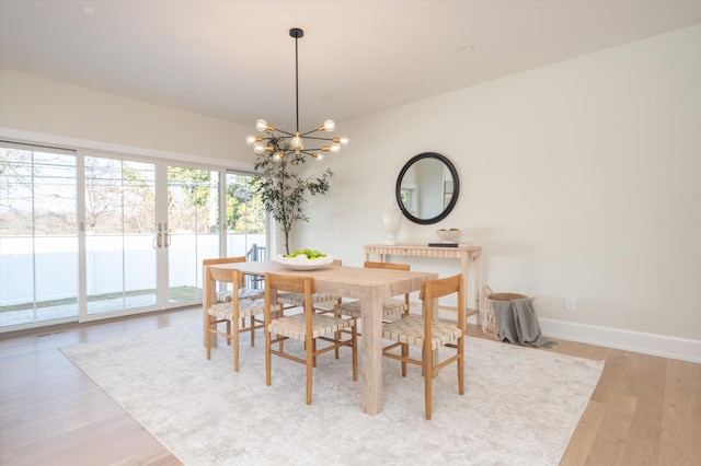 dining area featuring a notable chandelier and light hardwood / wood-style floors