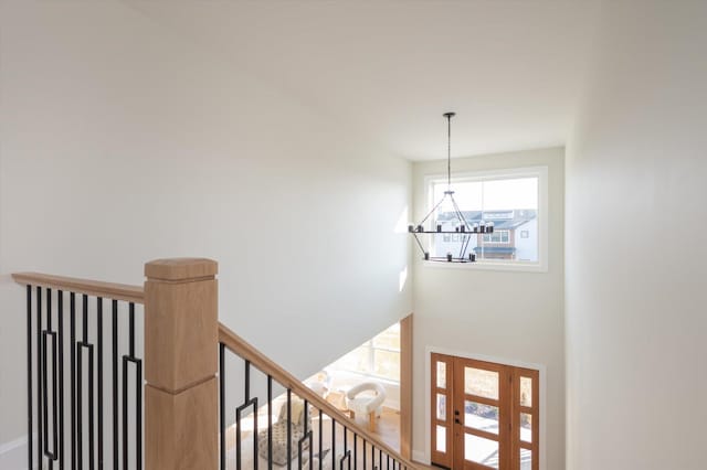 stairway with a notable chandelier