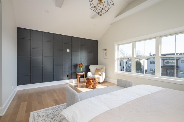 bedroom featuring vaulted ceiling with beams and light hardwood / wood-style floors