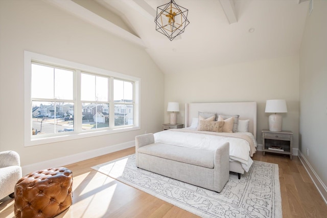 bedroom with vaulted ceiling with beams, light hardwood / wood-style flooring, and an inviting chandelier