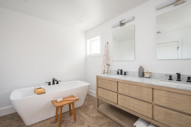 bathroom with a bath, vanity, and parquet flooring