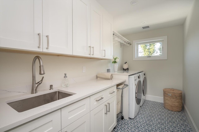 washroom with cabinets, sink, and washing machine and dryer