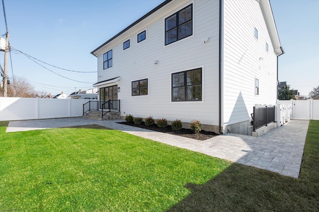 back of house featuring a patio area and a yard