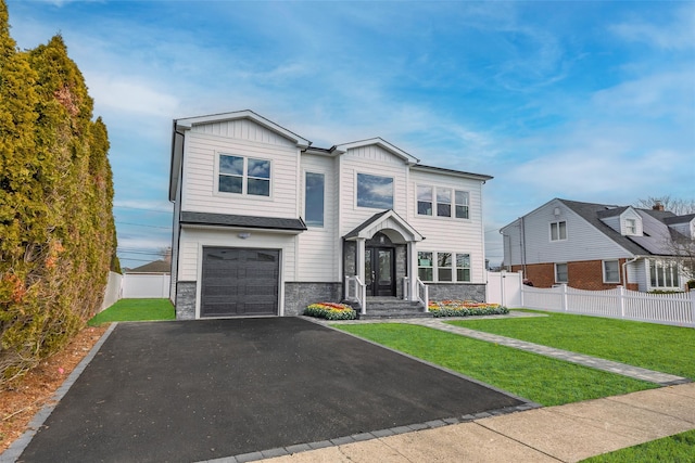 view of front of home featuring stone siding, a front lawn, board and batten siding, and fence