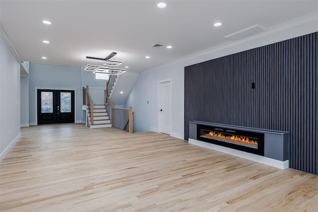 unfurnished living room featuring french doors, visible vents, stairway, ornamental molding, and wood finished floors