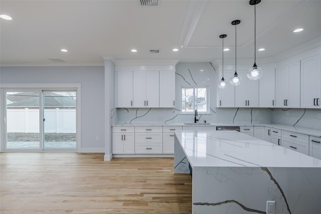 kitchen with light wood-style floors, tasteful backsplash, a sink, and recessed lighting