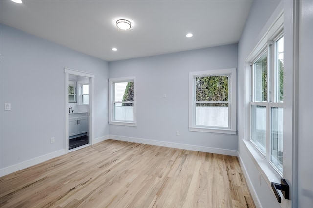 spare room featuring recessed lighting, light wood-style flooring, and baseboards