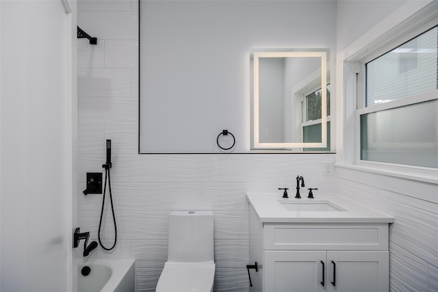 bathroom featuring toilet, tub / shower combination, tile walls, and vanity