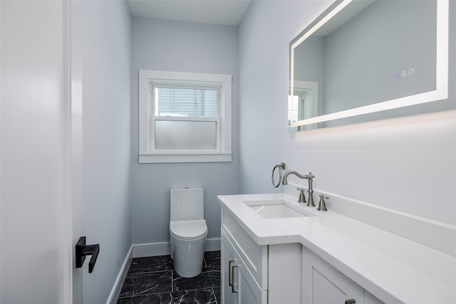 bathroom featuring marble finish floor, vanity, toilet, and baseboards