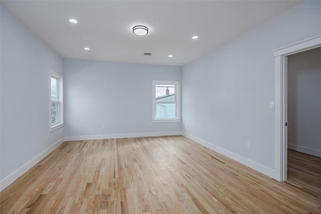 empty room featuring light wood finished floors, recessed lighting, visible vents, and baseboards